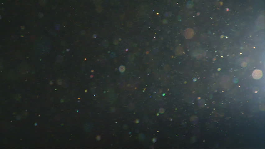 Dust Particles Floating In The Air Against Dark Background Stock