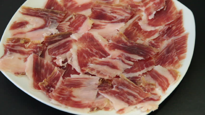 man picks jabugo ham slice