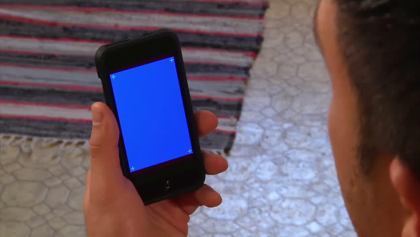 Male holding a mobile smartphone.  Blue screen for your custom video content with corner has marks for advanced tracking.  Shot 4:2:2 for clean keying.  Luma matte included.