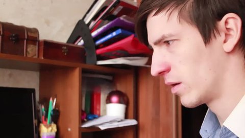 young guy has a runny nose, wipes his nose with a handkerchief, sneezes into his handkerchief