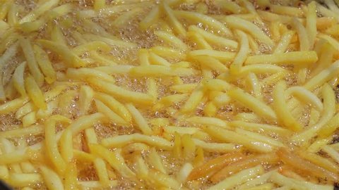French fries are fried in a large pot. close up. Street food festival. Potatoes Fried in oil.