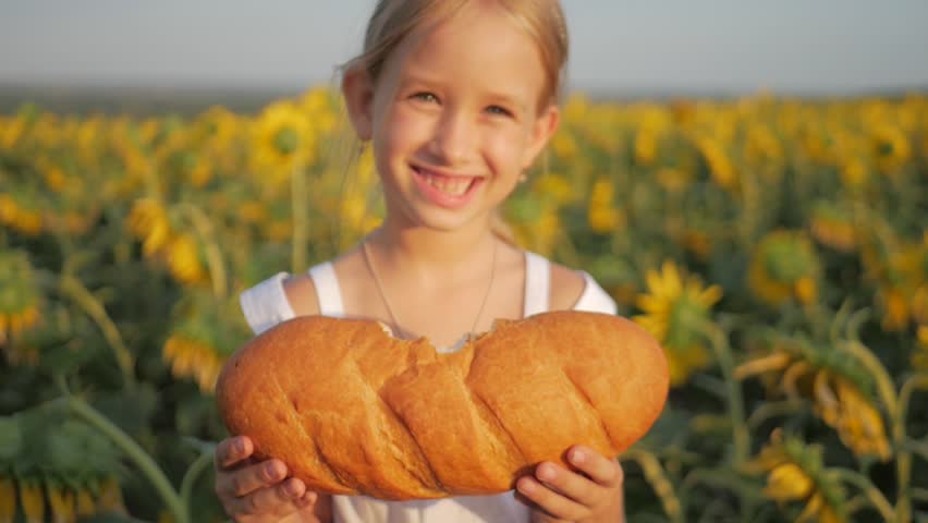 Хлеб счастья сайт. Девочка ест хлеб на поле. Хлеб счастья. Девочка, которая с удовольствием ест хлеб в поле. Девушка ест хлеб.