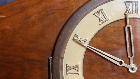 Close up of quarter of old wooden clock face. Minute hand moving fast and stops at 12 o'clock