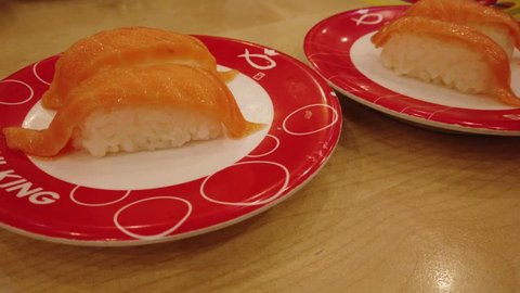 Kuching, Malaysia - May 2019. Pov Of A Man Eating Salmon Nigiri Sushi At  Sushi King Restaurant