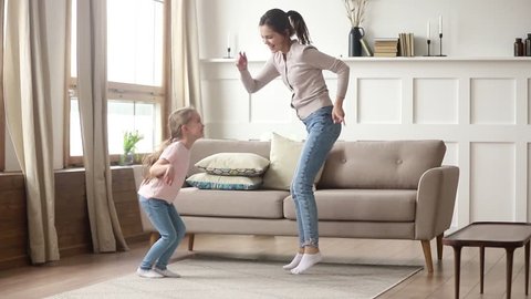 Webcam Schoolgirl Dance - Happy family young mom babysitter having fun with cute little kid girl  dancing in living room, carefree mother with child daughter laughing  jumping enjoying funny activity playing together at home