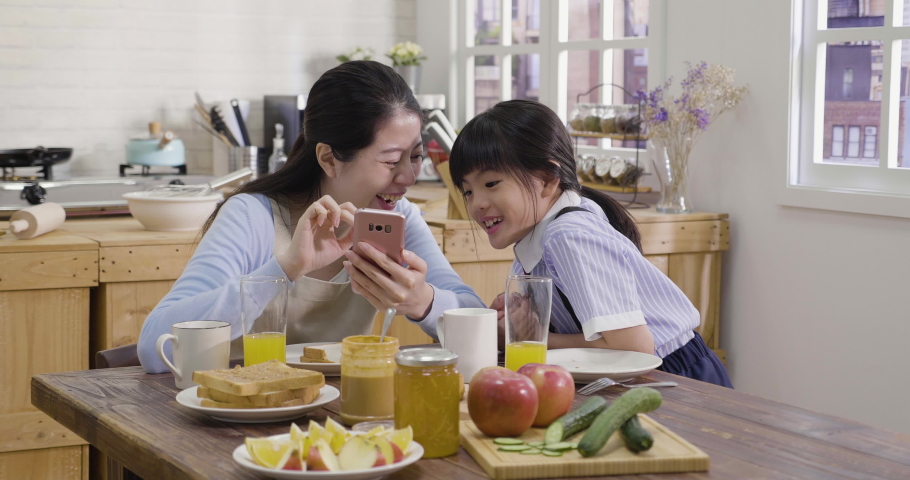 and daughter having dinner in their kitchen Gay couple and daughter having dinner in their kitchen Gay couple