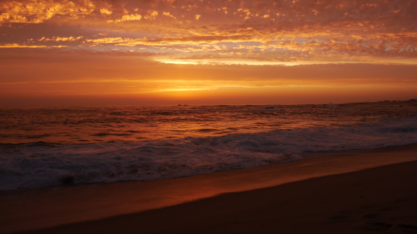 Low Angle Shot At Dusk On Beach With Beautiful Orange Sky