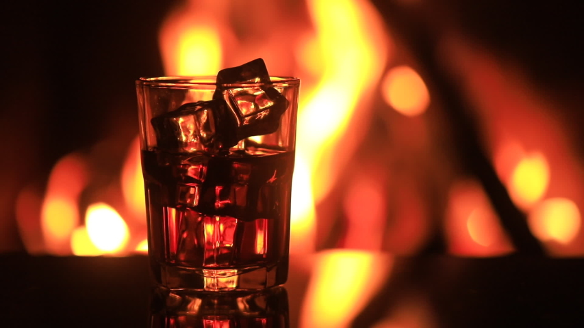 Glass Of Whiskey With Ice Near The Fireplace