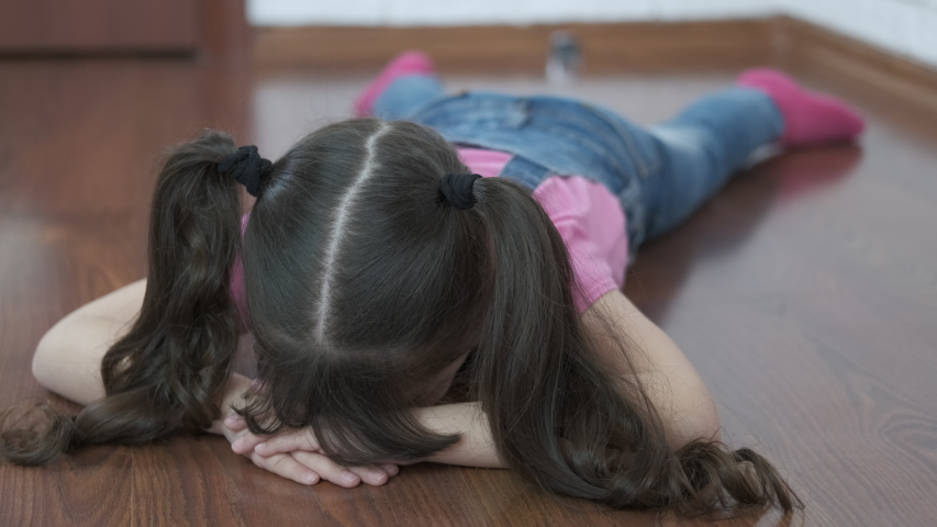 4k00 12a Sad Child Is Lying On The Floor Offended Little Girl Lies Face