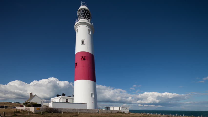 A Red And White Lighthouse Is Dwarfed By The Majesty Of The White ...