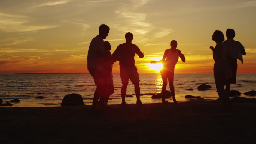 Four Friends Jumping On The Beach At Sunset Silhouetted Stock Footage ...