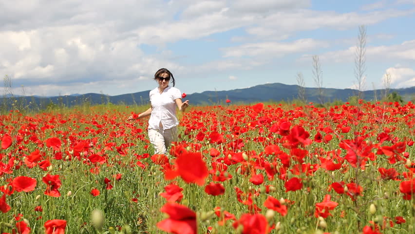 Beautiful Woman Walking Across A Poppy Field. Woman In A Poppy Field ...