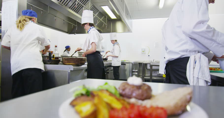 Restaurant Kitchen Video group of chefs talking cooking and slicing vegetables in a Restaurant Kitchen Video group of chefs talking cooking and slicing vegetables in a