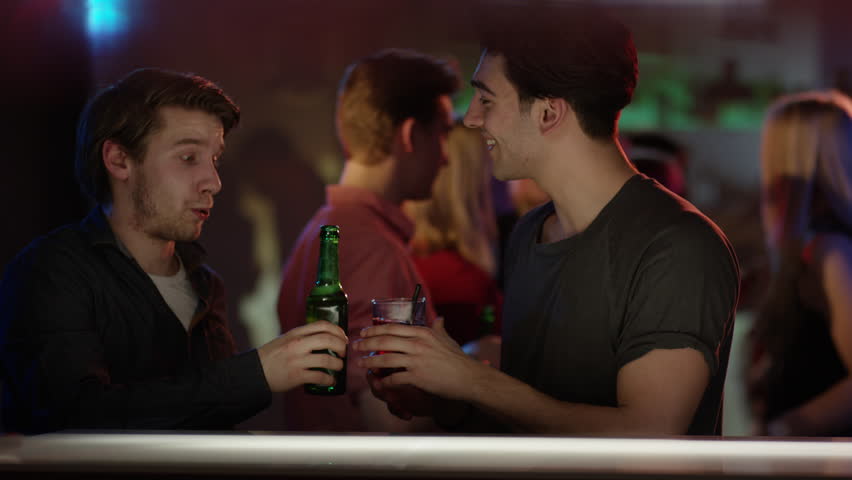 Friends Hanging Out In The Club Standing At The Bar With People Dancing ...