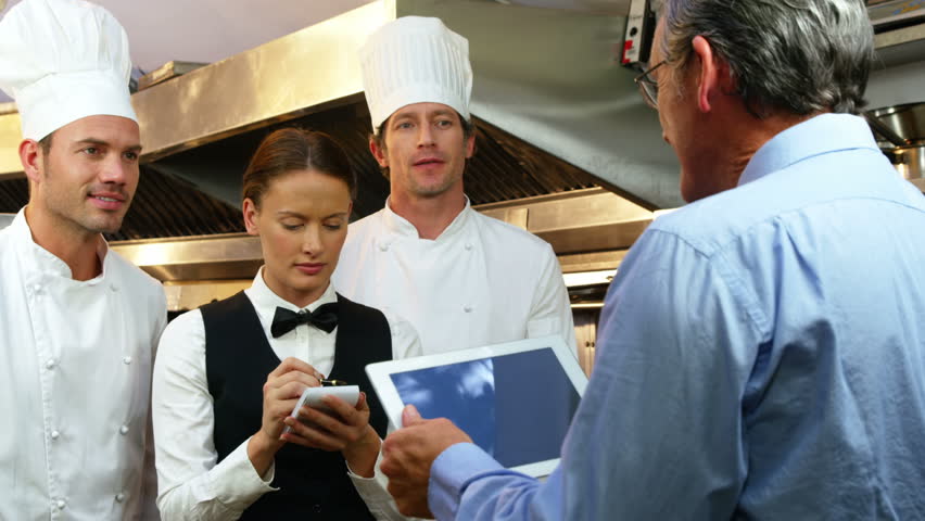 Restaurant Kitchen Staff happy restaurant staff smiling at camera in a commercial kitchen Restaurant Kitchen Staff happy restaurant staff smiling at camera in a commercial kitchen