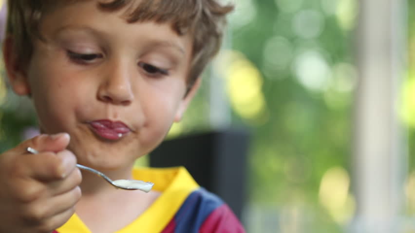 Young Boy Eating Yogurt With Spoon. 6 Year Old Kid Eating Supper Desert ...