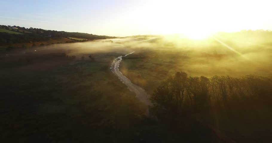 Countryside meadow, co Cork, Ireland with a nice sun coming through the glass of the lens, nice forest in the background of the hill.