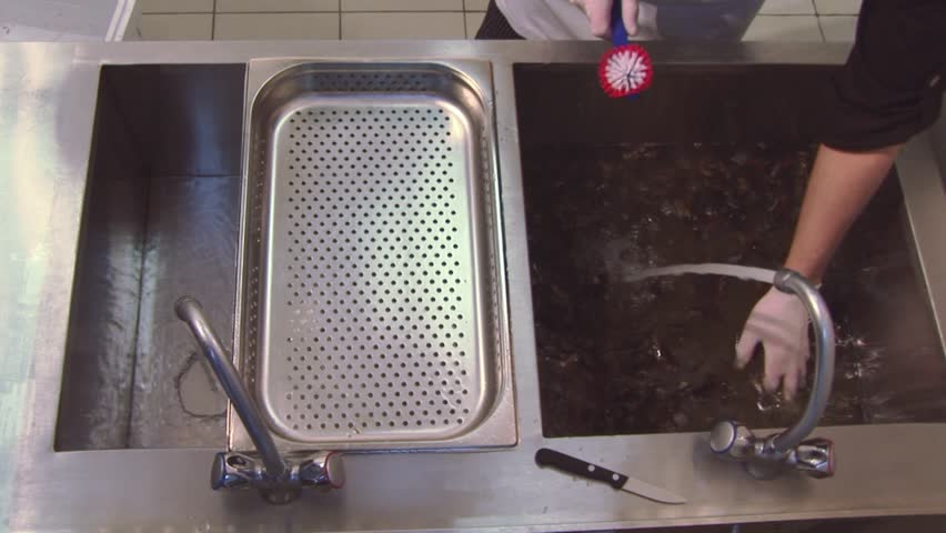 Restaurant Kitchen Gloves cook in gloves scrubbing raw mussels in sinkknife. colander Restaurant Kitchen Gloves cook in gloves scrubbing raw mussels in sinkknife. colander
