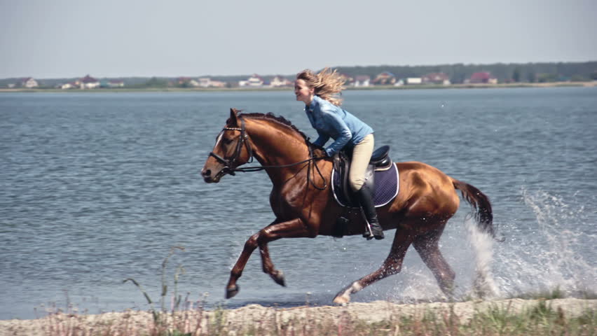 Slow Motion Tracking Of Young Female Riding On Galloping Horse Through