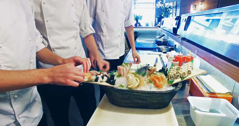 Restaurant Kitchen Video 4k video shooting: three professional chefs prepare sushi set in a Restaurant Kitchen Video 4k video shooting: three professional chefs prepare sushi set in a
