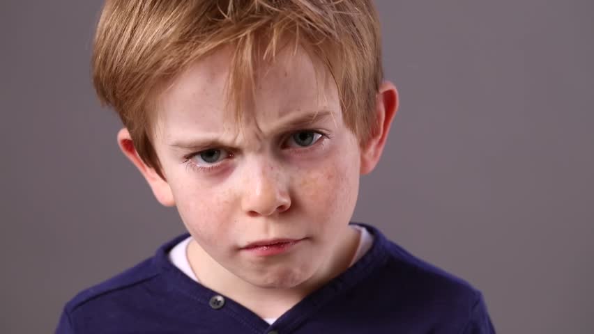 Cute 6-year Old Child With Red Hair Showing How To Look Mad, Angry ...