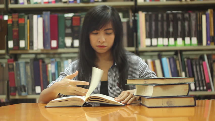 Stressed Student Studying And Taking Notes In The Library Surrounded By Books In College Stock -6779