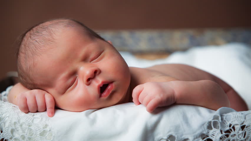 Close-up portrait of a beautiful sleeping baby on vintage suitcase
