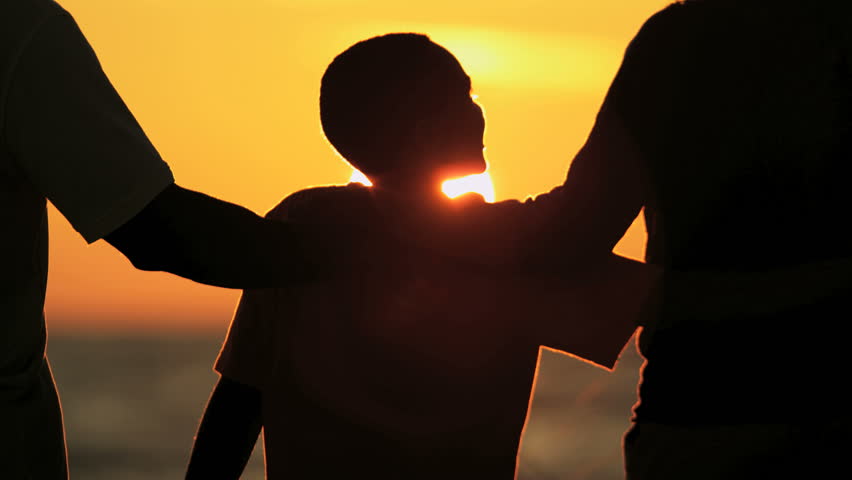 silhouette of carefree ethnic family enjoying sunset and togetherness on beach holiday 4k stock video