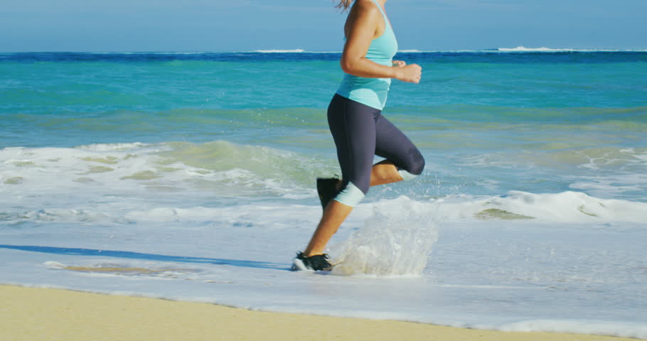 Волею неволей бегаем по морю. Бег у моря. Девушка в спортивном костюме бежит у моря. Девушка в спортивном белом костюме бежит у моря.