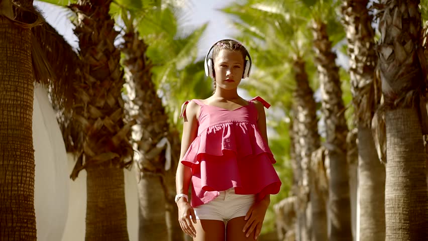 Slender Young Cute Teen Girl Dancing Broken Dancing In The Tropical Gardens Listening To Music In Big Headphones White Slender Young Cute Teen Girl Dancing Broken Dancing In The Tropical Gardens Listening To Music In Big Headphones White