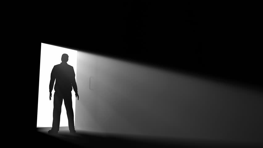 A Man Walking In A Dark Room With A Strong Light Coming From Behind ...