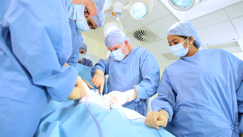 Multi Ethnic Medical Team Performing Operation In Hospital Operating ...