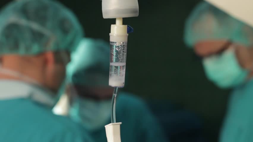 Intravenous Drip In Focus,surgeons Team Performing Operation In The ...