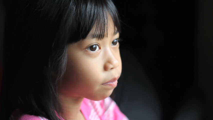 A Sad Lonely 8 Year Old Asian Girl Looks Towards The Camera After ...