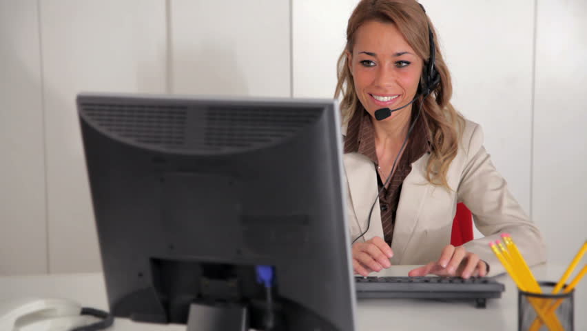 Stock Video Clip of Mid adult female receptionist working on computer ...