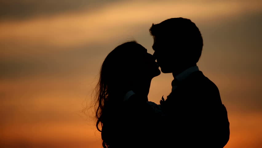 Silhouettes Of Man And Woman Kissing, Sunset Sky In Background Stock ...