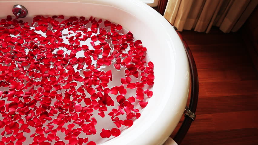 Tilt Up Shot Of Red Rose Petals In Bathtub With Running