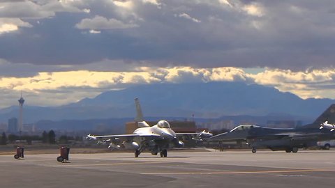 CIRCA 2010s - F-15 and F-16 fighter jets line up and taxi for takeoff in a military exercise.