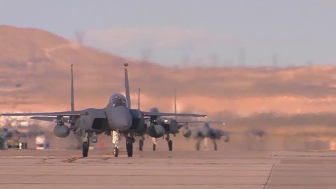 CIRCA 2010s - F-15 and F-16 fighter jets line up and taxi for takeoff in a military exercise.
